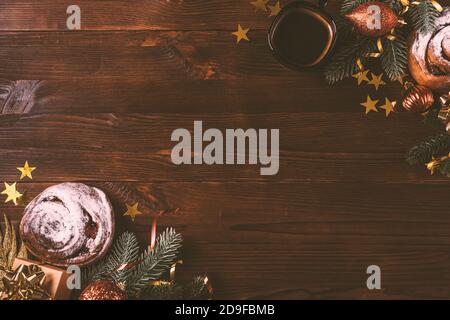 Christmas flat lay arrangement with coffee cup, homemade bakery, fir branches and decorations on dark wooden background. Stock Photo