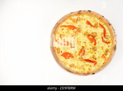 Spicy pizza with bell pepper bits. Take away food with white sauce and crunchy edges. Delivery and italian cuisine concept. Pizza with extra cheese, chicken and tomatoes isolated on white background. Stock Photo