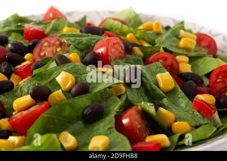 Mexican salad with black beans, corn,tomatoes,lettuce and pepper isolated on white background Stock Photo