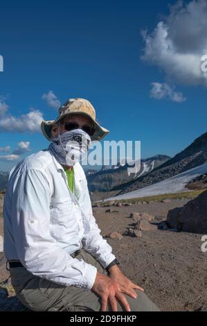 Man wearing a hiker's mask in the mountains Stock Photo
