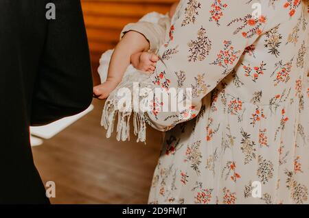 Feet of a toddler baby barefoot close-up in the arms of mother Stock Photo