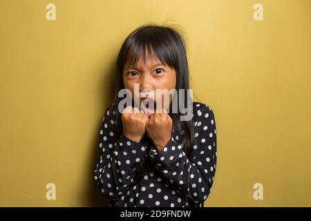 Asian little girl with punching fist to fight, aggressive and angry attack Stock Photo