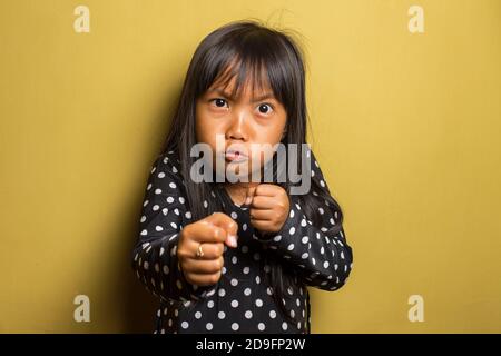 Asian little girl with punching fist to fight, aggressive and angry attack Stock Photo