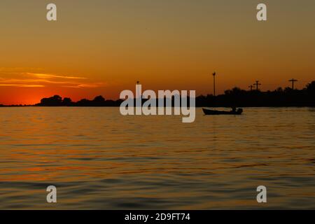 Sunrise in Danube's delta, with fishing boat in the shadows. Stock Photo