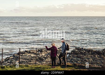 Everyday life. Mid age couple looking at the sea from rocky beach. Stock Photo