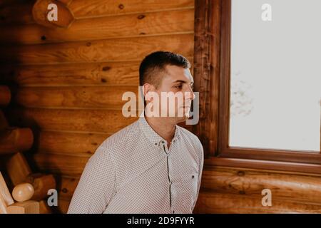 Black-haired man indoors on a wooden background Stock Photo