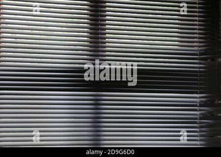 Venetian blinds with visible light. Sun shining through window blinds in a room. Abstract design texture Stock Photo