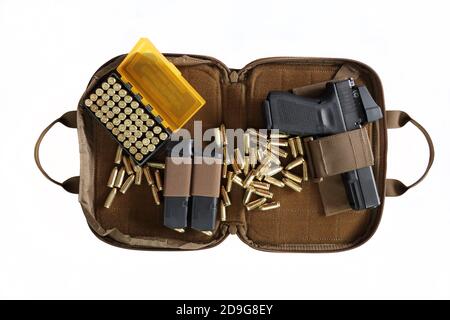 A bag containing a 9 mm pistol with magazines and a box of ammunition on a white background. Top view tactical hand gun Glock. Pistol wallet. Stock Photo