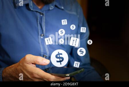 Man using a smartphone with US dollar and food or restaurant icons. Stock Photo