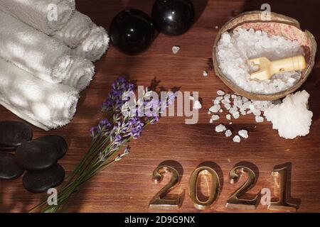 Spa set in white with sea salt towels and stones for hot massage and 2021 numbers. Stock Photo