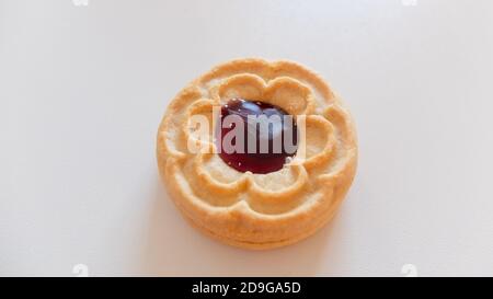 Round cookies with blueberry filling, isolated on light background Stock Photo
