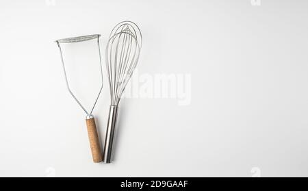 The whisk and the potato masher on white background. Culinary background, Stock Photo