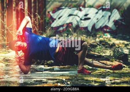 Handsome Man Keeping Balance On Hands in Warehouse - Muscular Athletic Bodybuilder Fitness Model Doing Handstand Push-up Stock Photo