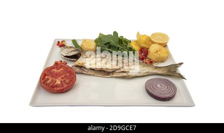 Closeup of a bluefish and appetizers served on a white plate isolated on a white  background Stock Photo