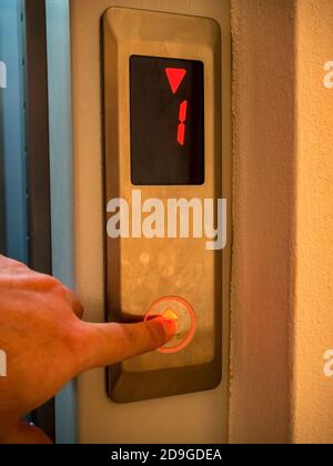 Hand presses the button of the elevator call Stock Photo