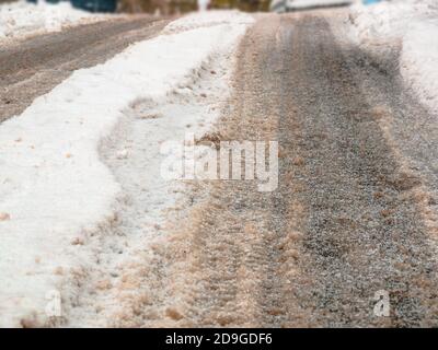 Tire tracks in the snow on the road - selective focus Stock Photo