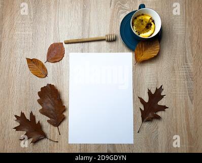 Autumn still life. Blank copy space card mockup of an autumn composition with brown leafs and tea on a wooden background. Fall and Thanksgiving concep Stock Photo