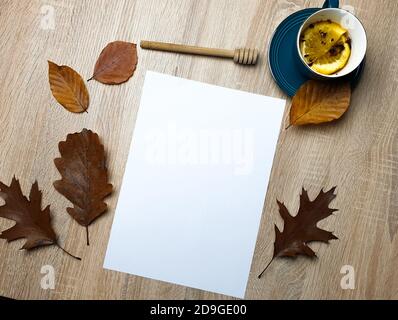 Autumn still life. Blank copy space card mockup of an autumn composition with brown leafs and tea on a wooden background. Fall and Thanksgiving concep Stock Photo