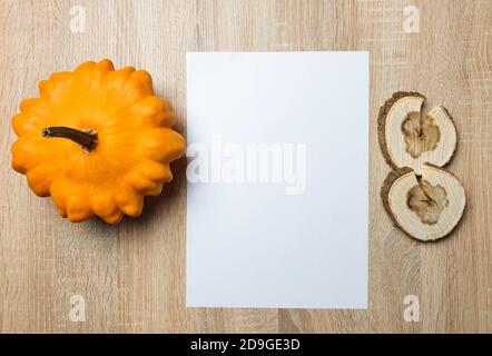 Autumn still life. Blank copy space card mockup of an autumn composition with pumpkin and leafs on a wooden background. Fall and Thanksgiving concept. Stock Photo