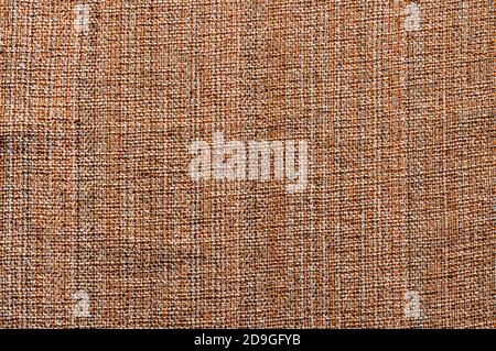 Brown textile fabric background.  close up of brown fabric cloth made of various textile threads. This top view dark fabric background can be used as Stock Photo