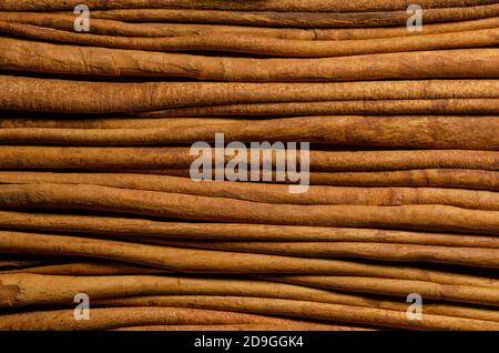 Dried cinnamon bark strips background. A brown spice from the inner bark of Cinnamomum verum, the true cinnamon tree. Aromatic condiment. Stock Photo