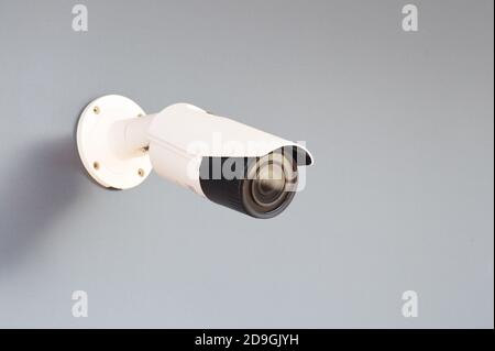 IP CCTV white camera installed on a gray wall - home security system concept Stock Photo