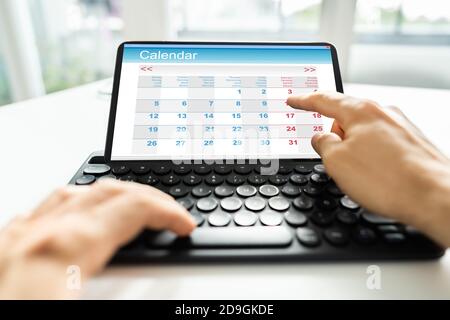 Man Looking At Calendar On Digital Tablet Stock Photo