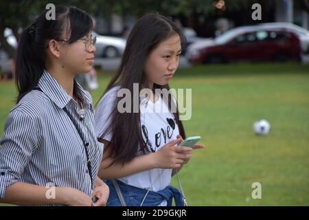 AUCKLAND, NEW ZEALAND - Nov 01, 2020: View of two teenage girls walking in park Stock Photo