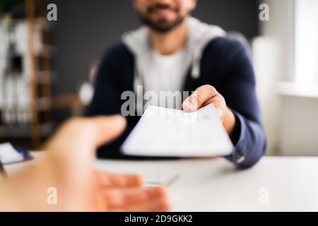 Man Giving Payroll Compensation Paycheck Or Cheque Stock Photo