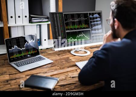 Stock Exchange Business Analyst Using Computer With Multiple Screen Stock Photo