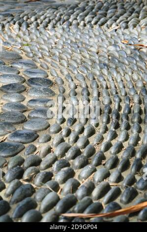 Perspective view of a cobbled stone sensory footpath made of smooth rounded pebbles. Stock Photo