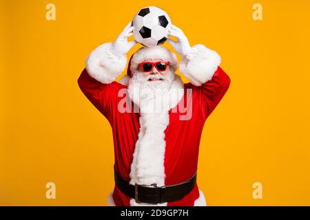 Portrait of his he nice attractive cheerful cheery Santa father holding in hands throwing ball having fun active life isolated over bright vivid shine Stock Photo