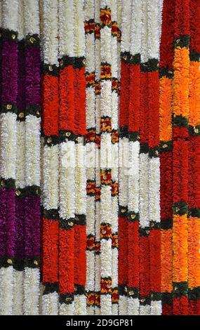 Colourful flower garlands for sale, hanging in an Indian shop. Stock Photo