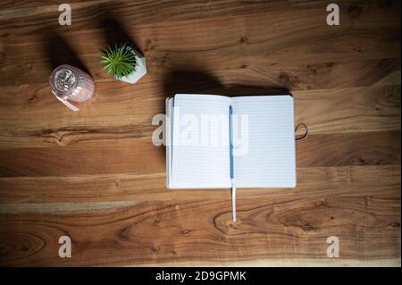 Top view of an open blank notebook with pencil on it lying on wooden desk. Stock Photo