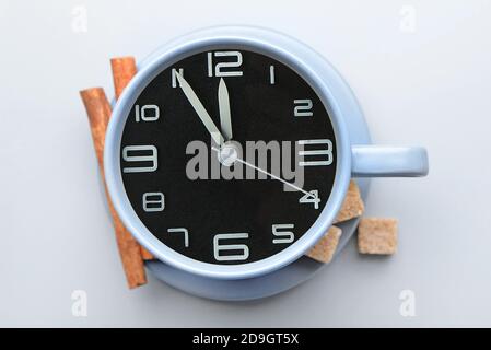 Cup with clock on light background Stock Photo