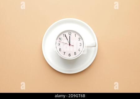 Cup with clock on color background Stock Photo