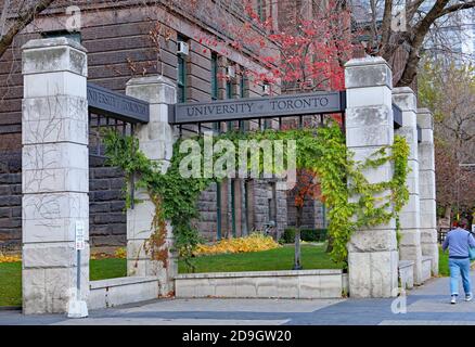 Toronto, Canada - November 5, 2020:  The entrance gate to the main campus of the University of Toronto, with a large old academic building in the back Stock Photo