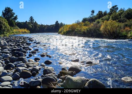 Sunlight sparkling on the rocky Tongariro River, New Zealand, on a sunny autumn day Stock Photo