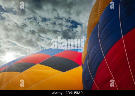 two multicolored balloons against cloudy skies Stock Photo