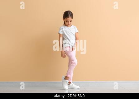 Little diabetic girl giving herself insulin injection near color wall Stock Photo