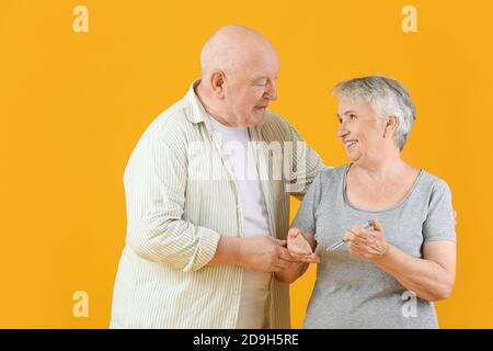 Senior diabetic couple with insulin syringe on color background Stock Photo