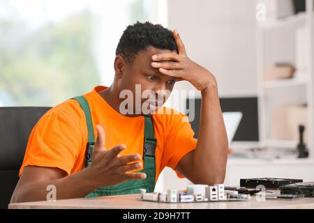 Stressed technician repairing PC in service center Stock Photo