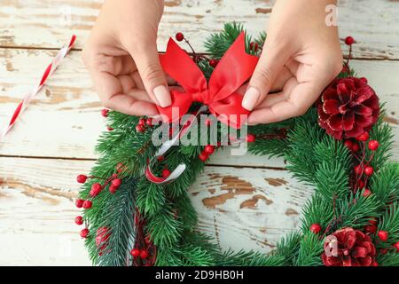 Woman making beautiful Christmas wreath on table Stock Photo