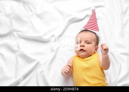 Cute little baby in elf hat lying on 