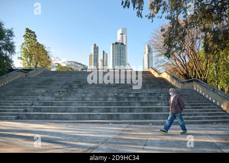 Caba, Buenos Aires / Argentina; Nov 4, 2020: Man walking through a park in Puerto Madero wearing a face mask to protect himself from the coronavirus, Stock Photo