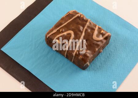 Milk chocolate wafer cake with nuts snack on blue and black napkins for sharing on white background Stock Photo