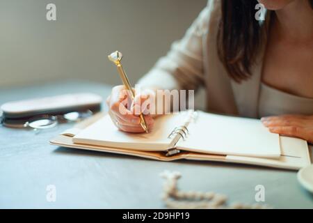 Beautiful young woman in suit writing her business plans while drinking coffee on break time Stock Photo