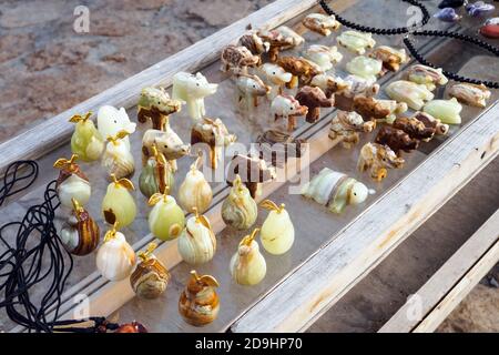 Onyx stone figurines on glass panel on street Stock Photo