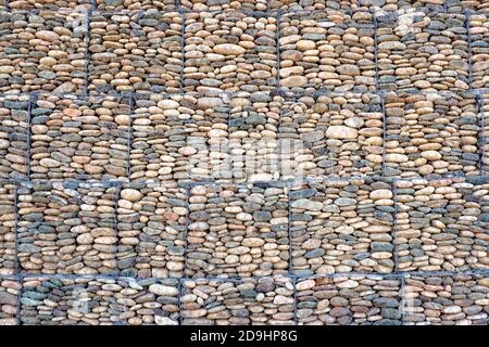 Stone gabion wall texture background. Fence from mesh and stone for erosion control. Stock Photo