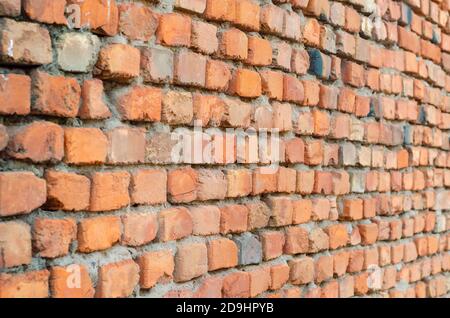 Red brick wall in receding perspective. Geometric composition of rectangular clay bricks. Multitasking background. Without anyone. Stock Photo